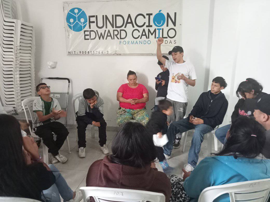 Jóvenes en círculo bajo el banner de la fundación